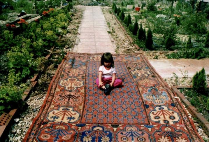 The author as a toddler on a rare antique Khotan rug that went on to be exhibited at the Hali Fair.